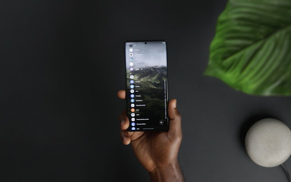 Hand holding a smartphone with application icons on screen