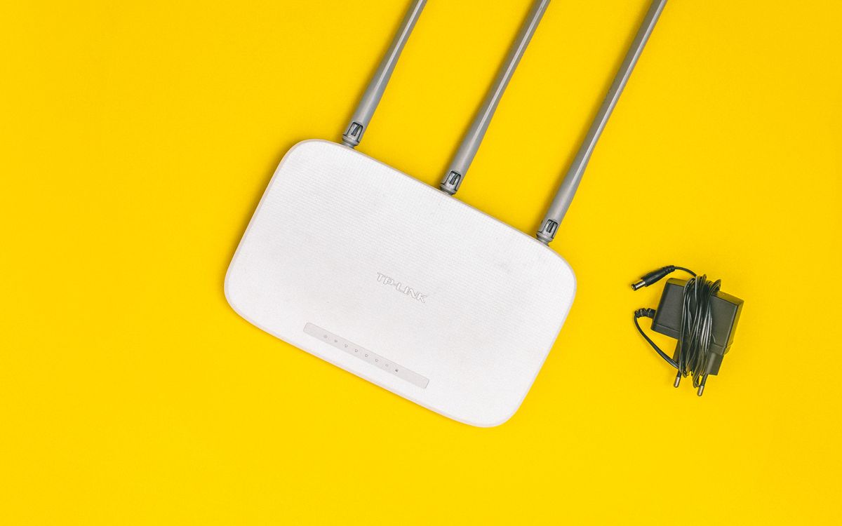 White Wi-Fi router against a yellow background