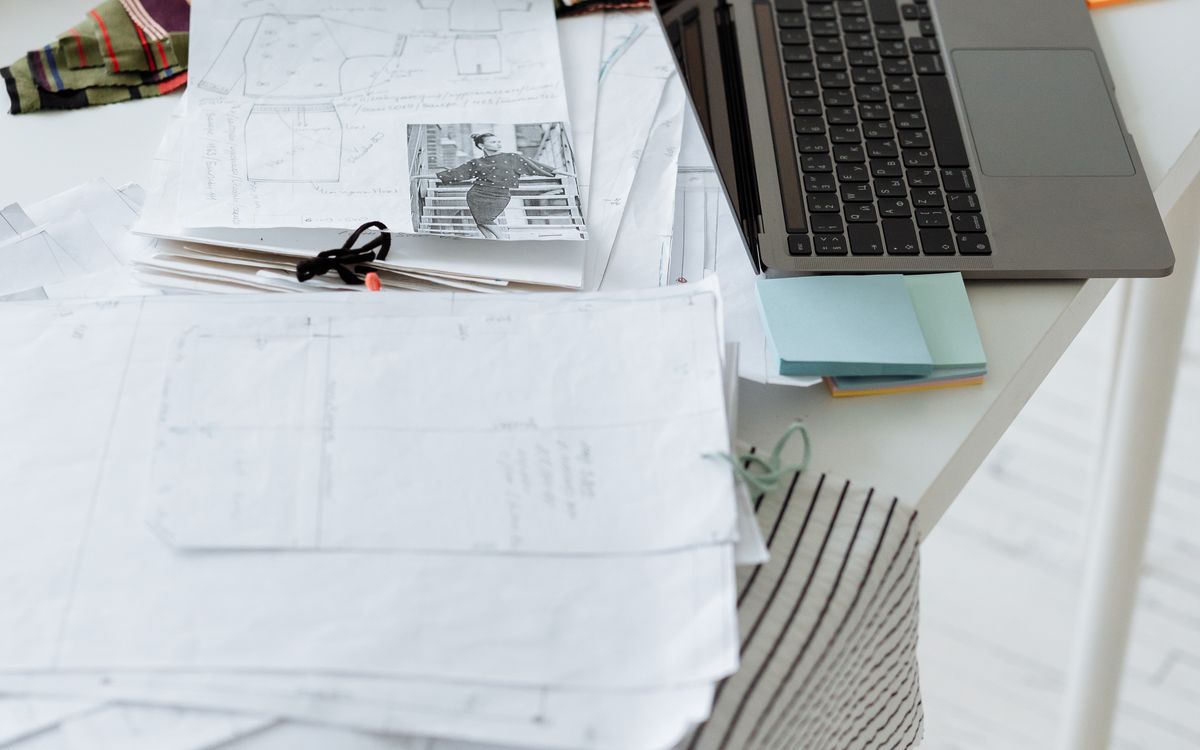 Laptop and design documents arranged on a desk