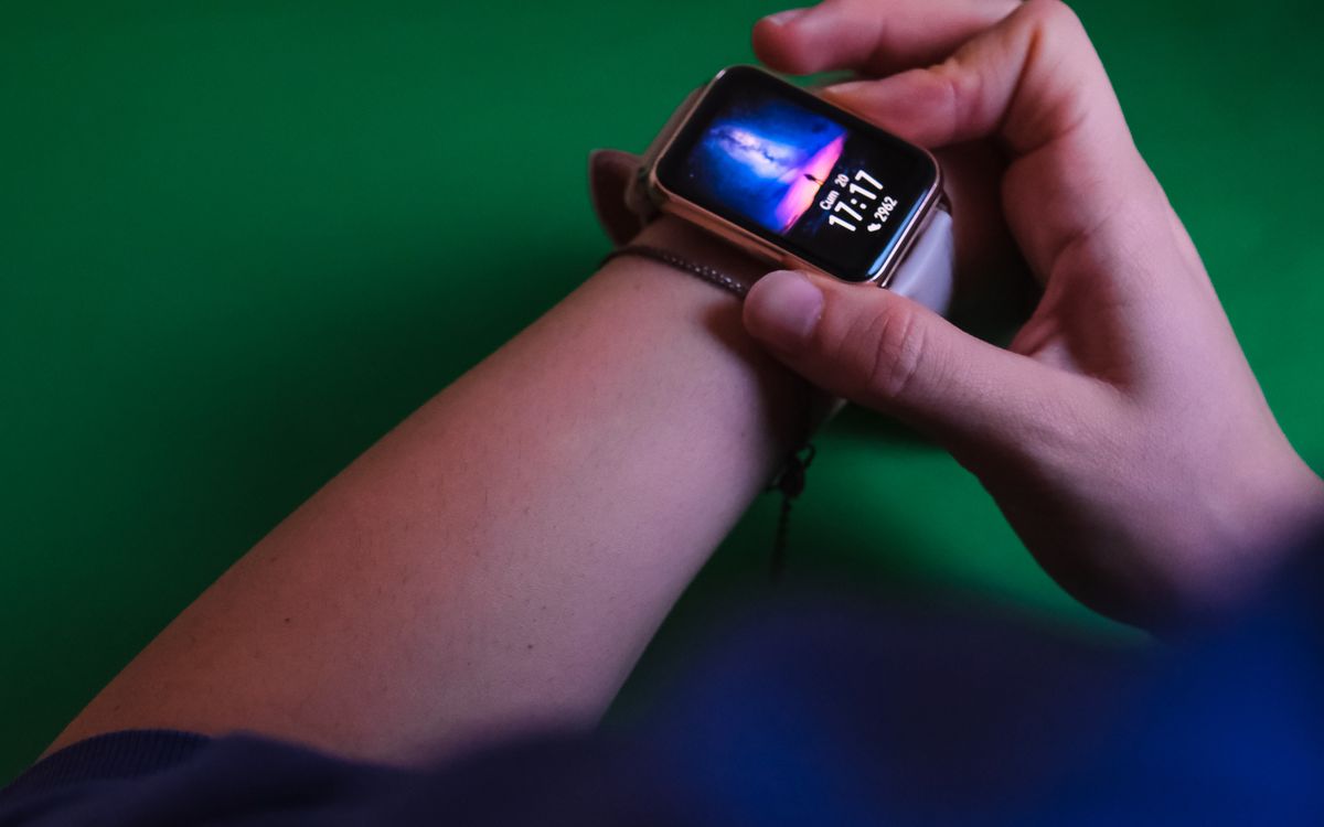 Person interacting with a smartwatch outdoors