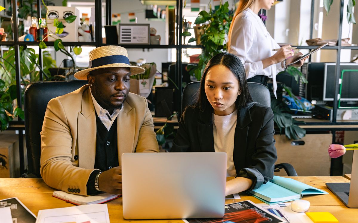 Colleagues collaborating at a laptop in an office